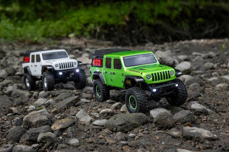 Two Axial SCX24 Jeep Gladiator crawlers on a rocky creek bed — Rock Crawlers at RC Hobby Pros